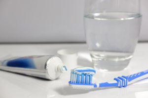 brush toothpaste and glass with water